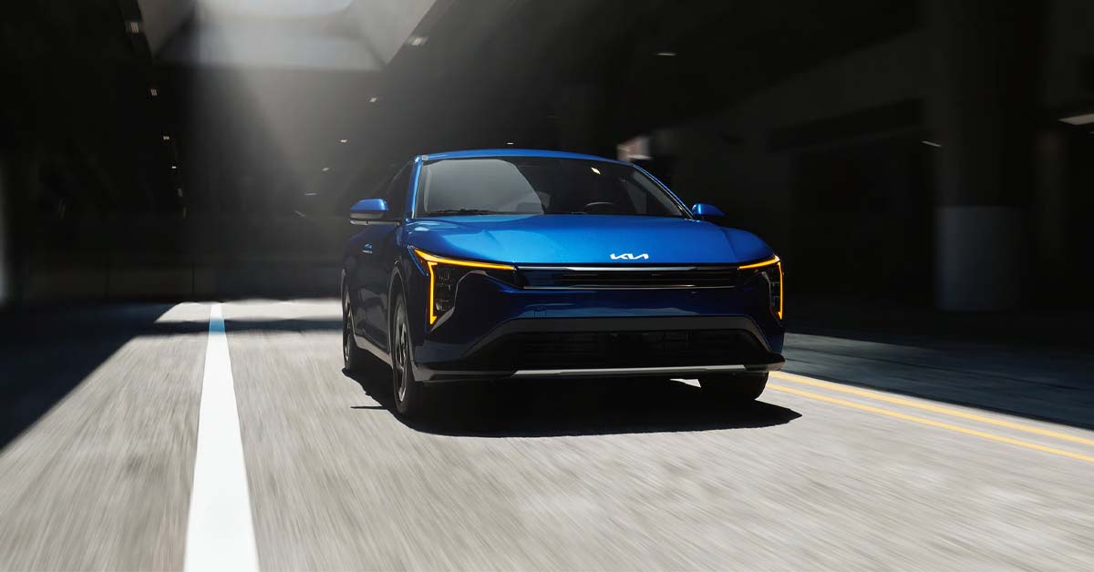 a blue 2026 Kia K4 driving down the road